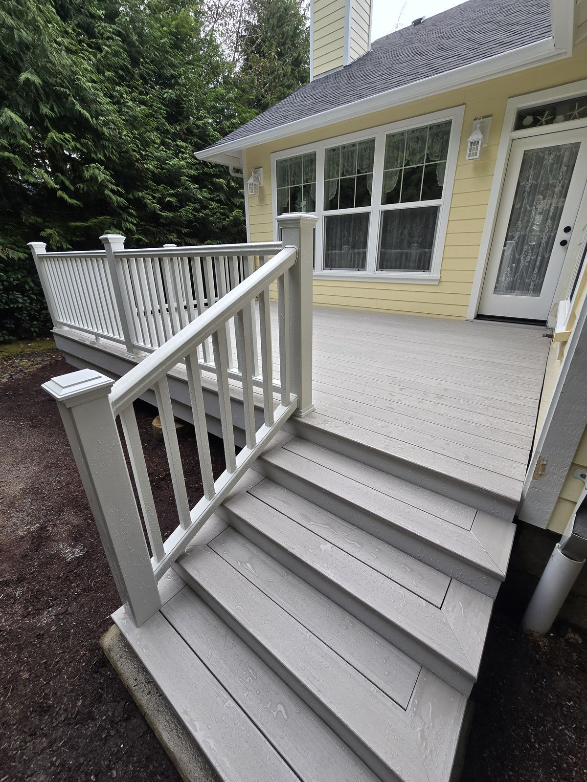 Composite deck with steps and white railing in Siletz